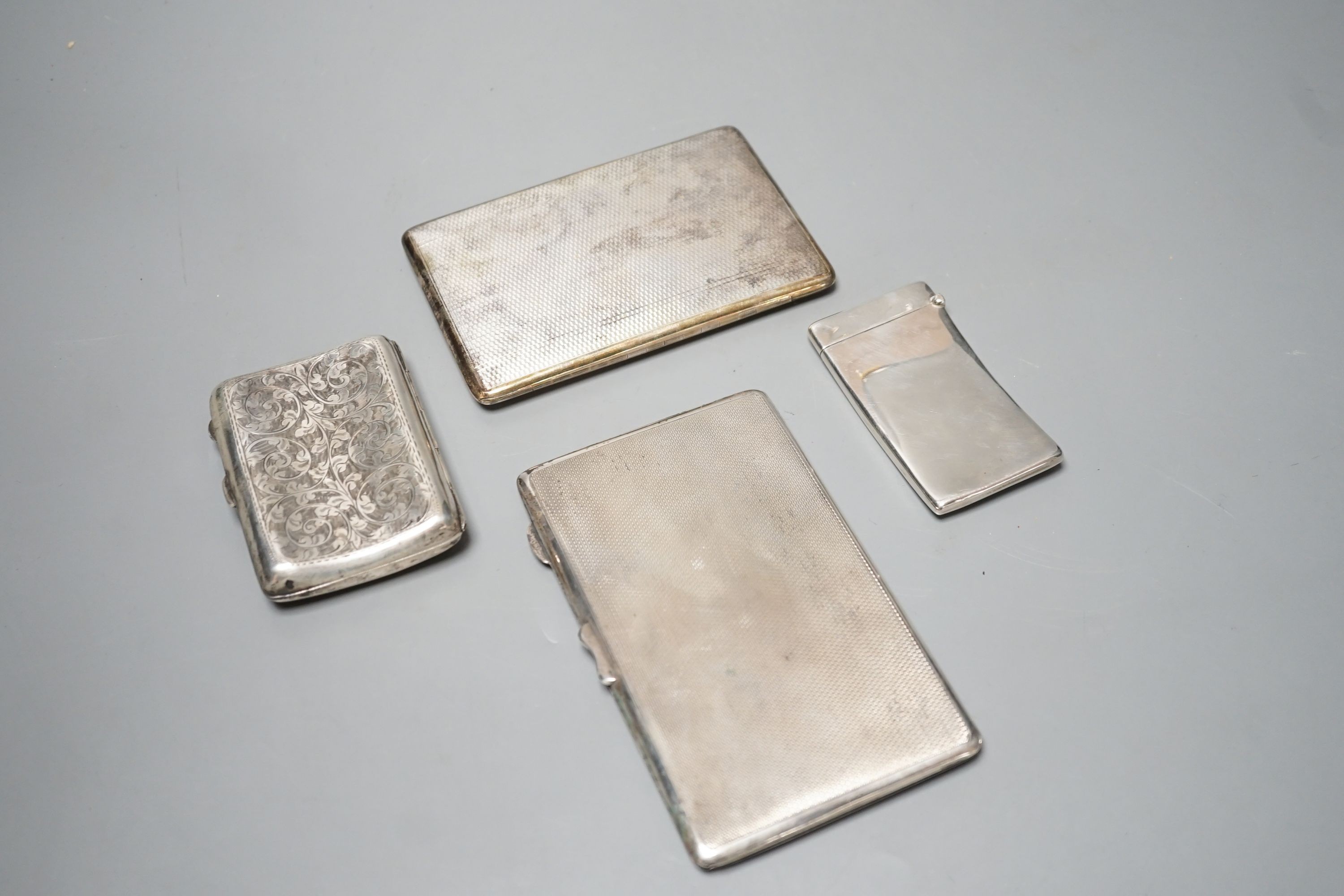 Three assorted silver cigarette cases and a silver card case, largest 14cm, gross 14oz.